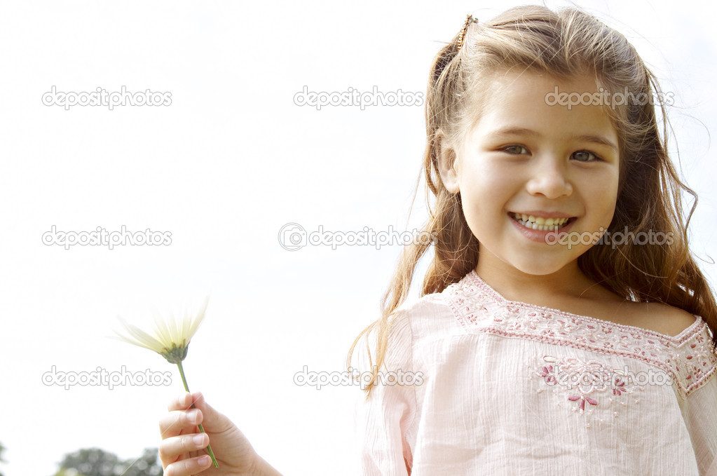 portrait of a young girl holding a daisy flower in her hand