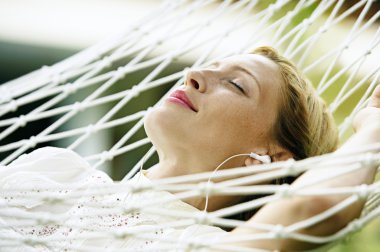 attractive blonde woman laying down on a hammock clipart