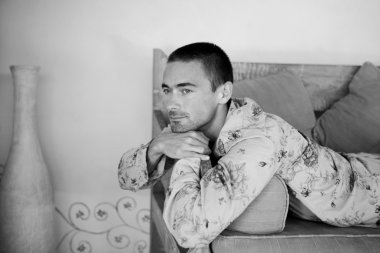 çekici bir genç adam kanepede rahatlatıcı