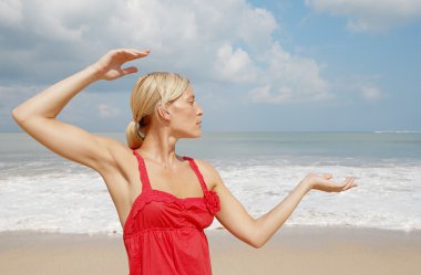 pratik Yoga bir plajda çekici genç bir kadın.