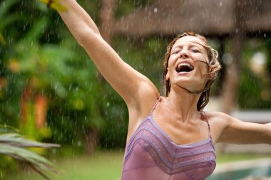 beautiful happy woman enjoying tropical rain