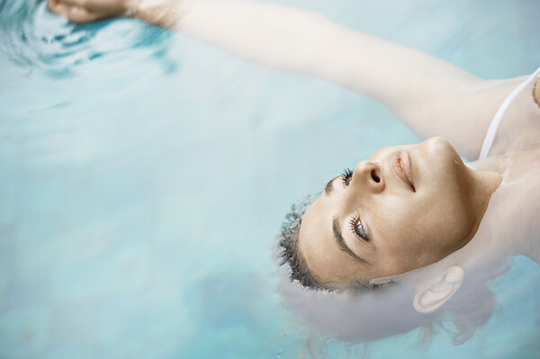 привлекательная молодая женщина, плавающая по голубой воде
.