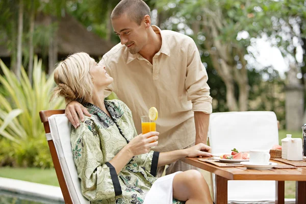 Pareja joven sonriendo mientras toma un desayuno de lujo — Foto de Stock