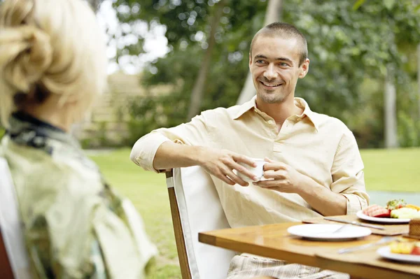 Jovem casal tomando um café da manhã saudável no jardim . — Fotografia de Stock