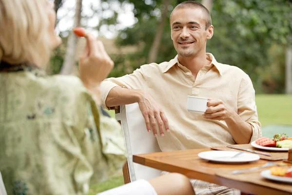 Atractiva pareja desayunando en un jardín exótico — Foto de Stock