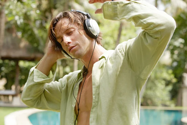 Mladý muž poslouchající hudbu se sluchátky — Stock fotografie