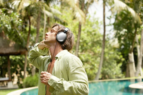 Ung attraktiv man lyssnar på musik med hörlurar — Stockfoto