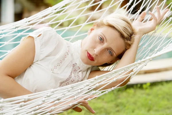 Aantrekkelijke vrouw tot vaststelling van en ontspannen op een witte hangmat — Stockfoto