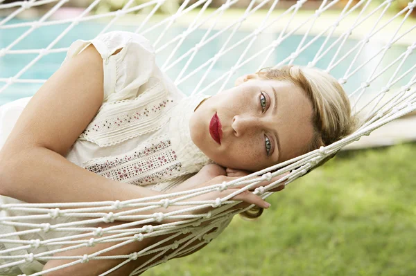 Attractive blonde woman laying down on a hammock — Stock Photo, Image