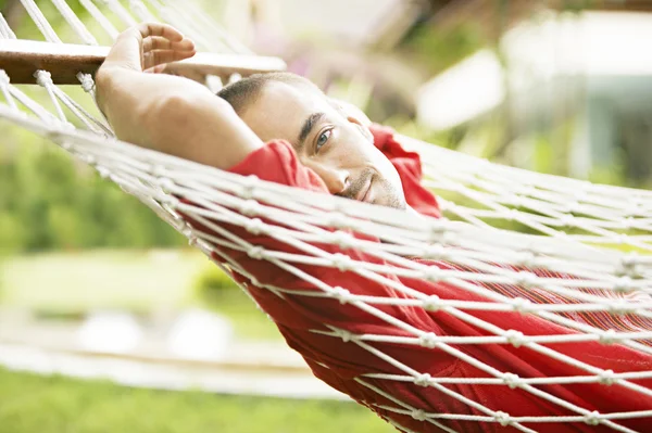 Jovem relaxante em uma rede — Fotografia de Stock