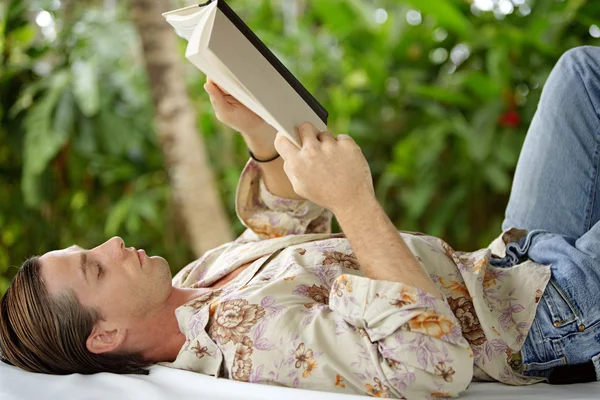 Atrakcyjny młody człowiek czytając książkę — Zdjęcie stockowe