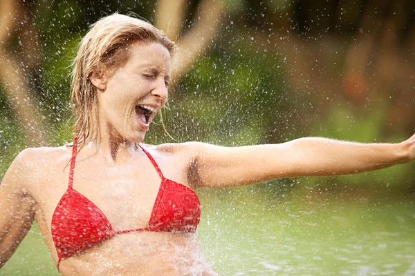 Aantrekkelijke jonge vrouw genieten van het spatten van het water op haar lichaam — Stockfoto
