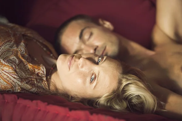 Retrato de um jovem casal deitado em um sofá . — Fotografia de Stock