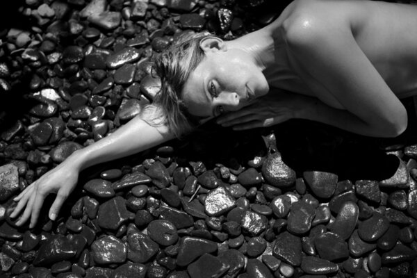 attractive woman laying down on natural stones