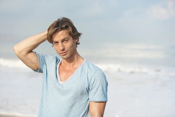 Jeune homme attrayant sur la plage avec la mer en arrière-plan . — Photo