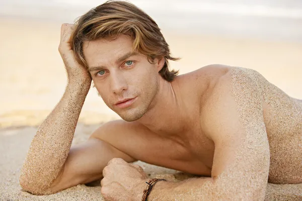 Portrait d'un jeune homme séduisant bronzer sur la plage . — Photo