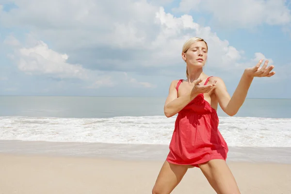 Retrato de una mujer atractiva practicando artes marciales en la playa . —  Fotos de Stock