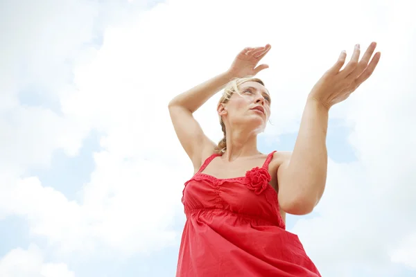 Bajo la vista de una atractiva mujer practicando artes marciales contra un cielo azul . —  Fotos de Stock