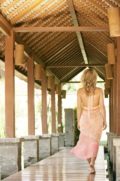 Mujer rubia joven caminando por un sendero de madera — Foto de Stock