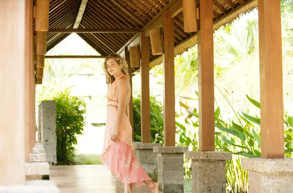 Attractive woman walking down a wooden walkway — Stock Photo, Image