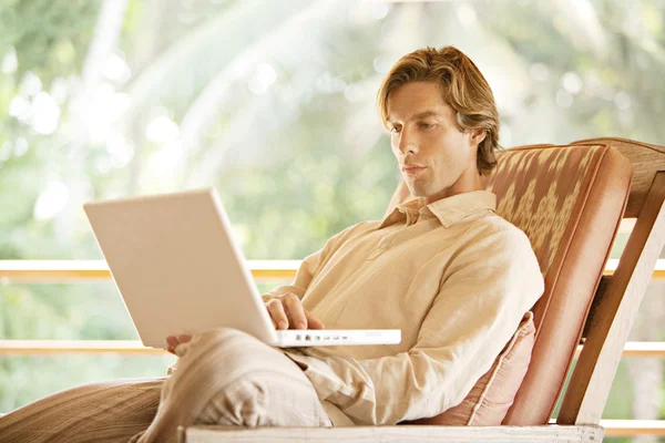 Hombre joven usando un ordenador portátil — Foto de Stock