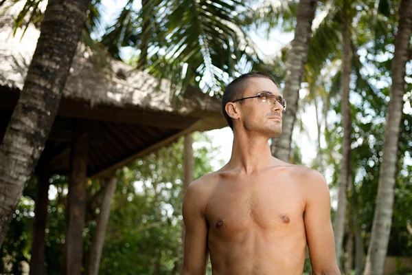 Attraente giovane uomo godendo la natura mentre in vacanza in una destinazione tropicale . — Foto Stock