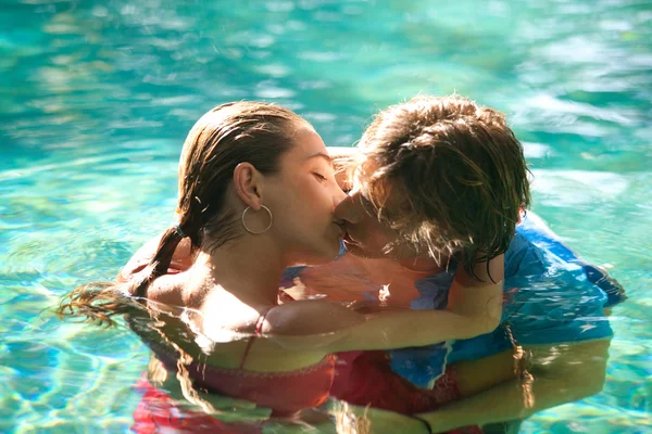 Exy young couple submerged in a swimming pool while dressed — Stock Photo, Image