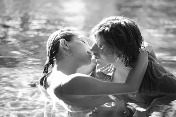 Sexy jovem casal submerso em uma piscina enquanto vestido — Fotografia de Stock