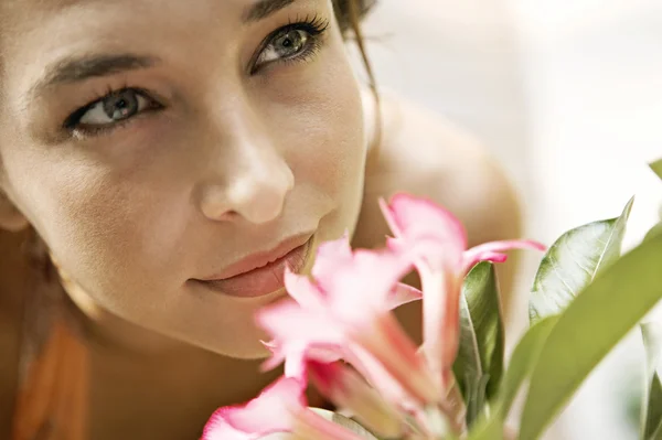 Beautiful young woman smelling a pink flower Royalty Free Stock Images
