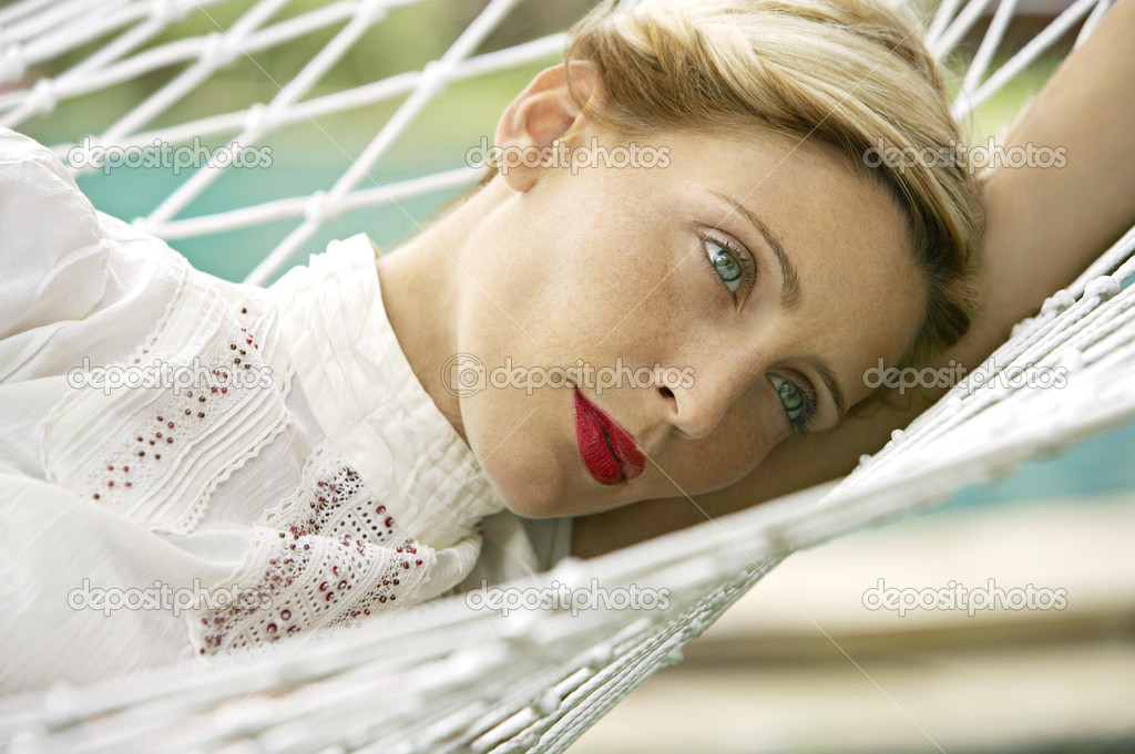 attractive blonde woman laying down on a hammock