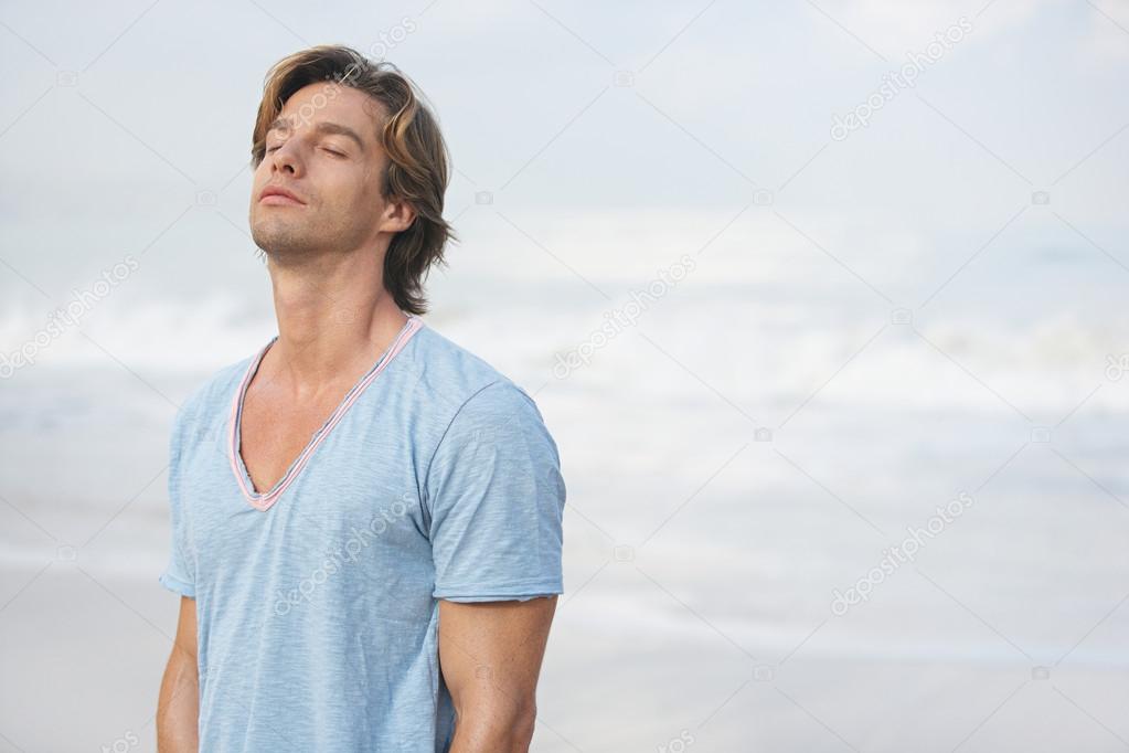 attractive man breathing fresh air while on the beach