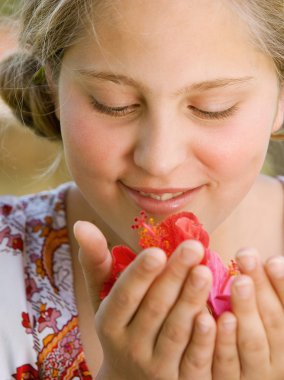hibiscus çiçek kokulu ve gülümseyen bir genç kız portresi kapatmak.