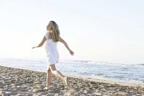 arka plan mavi gökyüzü ile bir plaj sahil çalışan sarışın kız.