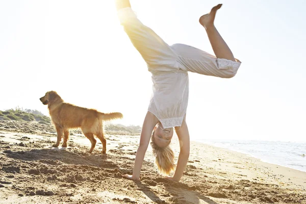 Mädchen mit Hund am Strand, Karthager mit der Sonne, die durchsickert. — Stockfoto