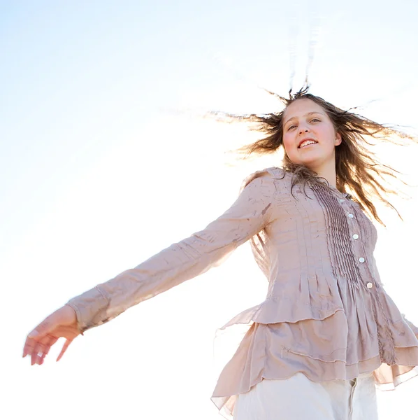 Низкая перспектива молодой девушки, подбрасывающей мокрые волосы в воздух, улыбающейся на фоне неба . — стоковое фото