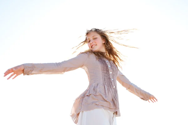 Faible perspective d'une jeune fille tapant ses cheveux mouillés dans l'air, souriant contre le ciel . — Photo