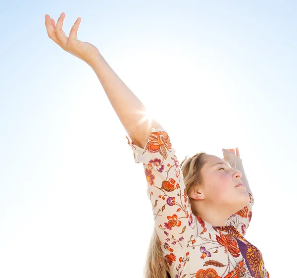 Young girl breathing fresh air with her arms raised against a blue sky — Stock Photo, Image