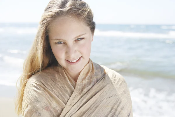 Retrato de uma menina loira em pé na praia, sorrindo . — Fotografia de Stock