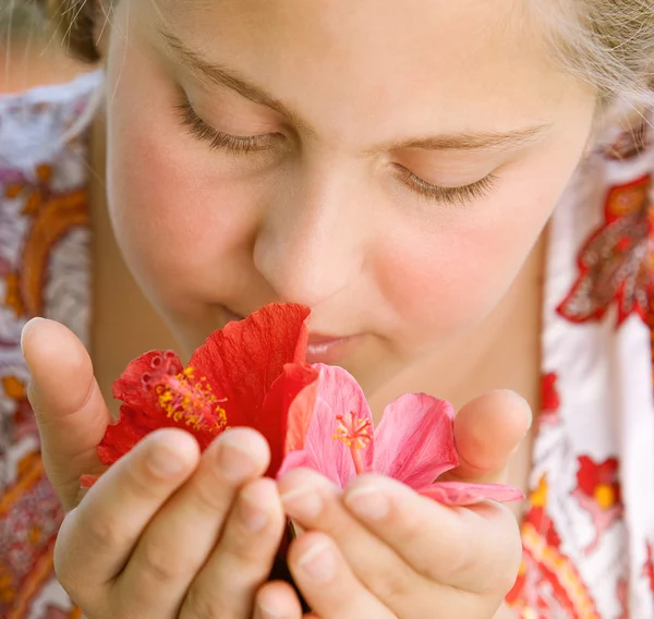 Retrato de cerca de una adolescente oliendo flores de hibisco . —  Fotos de Stock