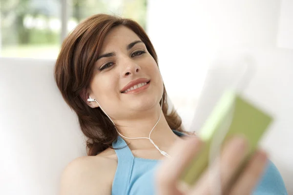 Jeune femme avec un lecteur mp3 écouter de la musique — Photo