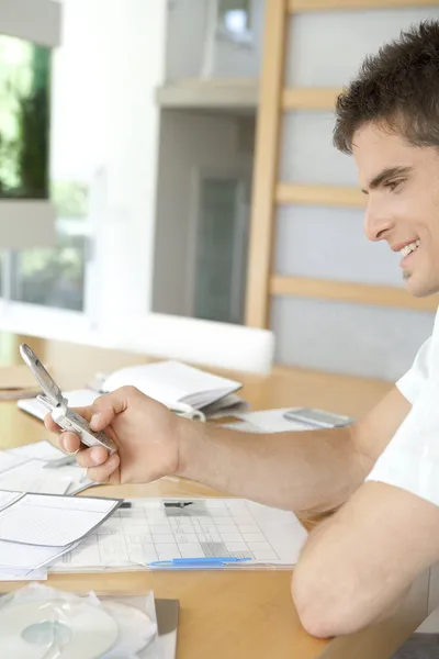 Jonge man aan het werk op zijn financiën in zijn huis keuken. — Stockfoto