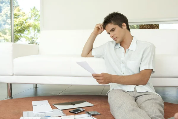 Young professional working on home finances in living room. — Stock Photo, Image