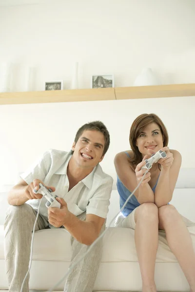 Hombre y mujer jugando videojuegos en casa . — Foto de Stock