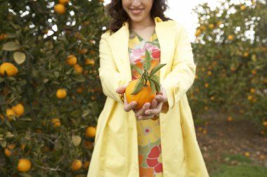 taze turuncu kameraya doğru tutan kadın