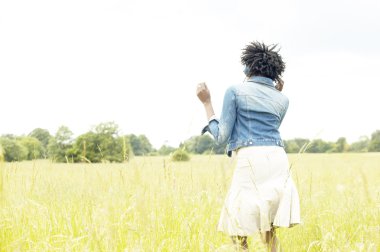 atractiva mujer negra de pie en un campo de hierba
