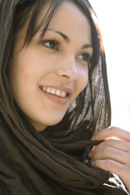 yakın bir kafa giyen bir Müslüman kadın portresi eşarp, gülümseyen.