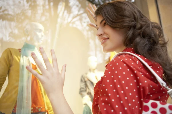 Mujer joven mirando el escaparate de la tienda de moda, soñando día . — Foto de Stock