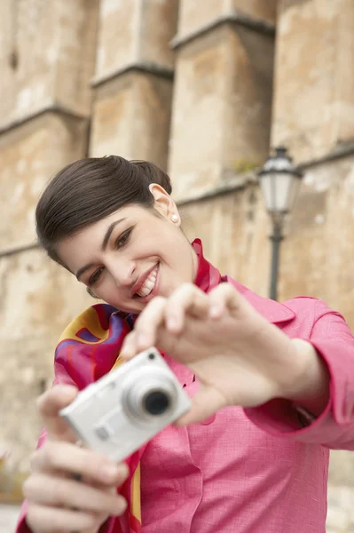 Elegante jovem turista tirar fotos perto de um monumento . — Fotografia de Stock