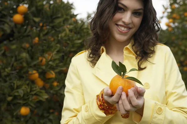 Mladá žena držící oranžová — Stock fotografie