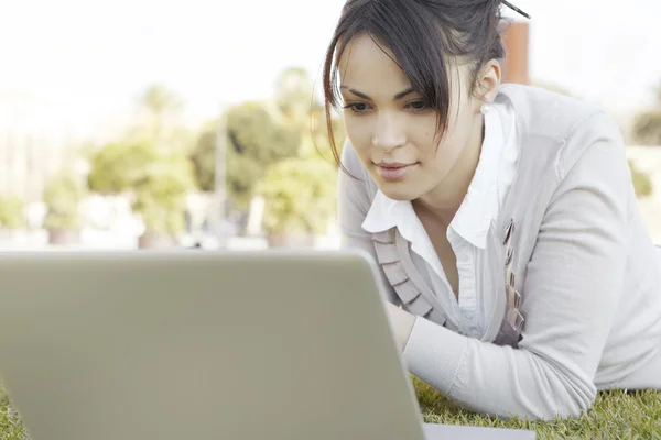 Portret van een jonge vrouw met behulp van een laptopcomputer — Stockfoto